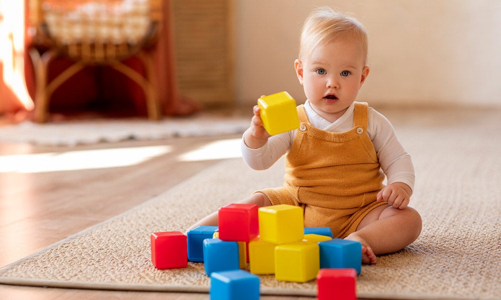 baby playing with colorful build- baby edge
