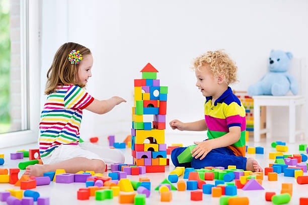 kids building a block tower from