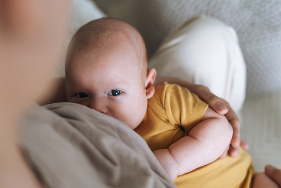 young mother breastfeeding your 2 3 month baby boy lying on blanket at home