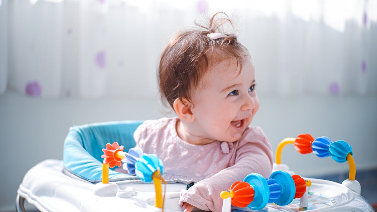 why-choose-us A happy baby plays with a colorful toy indoors, showcasing joy and curiosity.