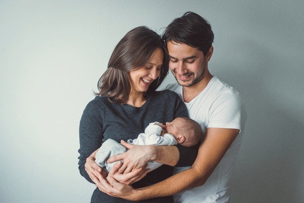 woman man holding newborn mom baby edge